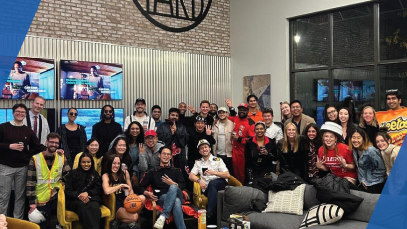 A large group of people pose together in a modern indoor lounge.