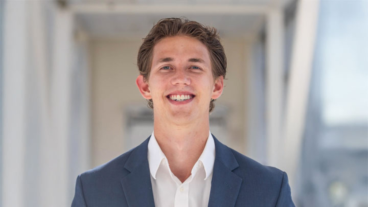 Photo of Max Wagner, Full-Time MBA student at Michigan Ross. He's wearing a navy blue suit with a white shirt underneath and has brown hair and is smiling. 