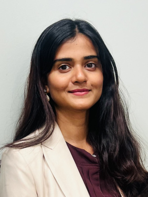 A woman smiling and wearing a blazer