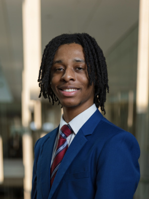 Smiling black male with locs and navy blue suit