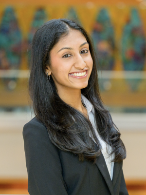 Headshot of Navya Singh, smiling in a black blazer and white shirt