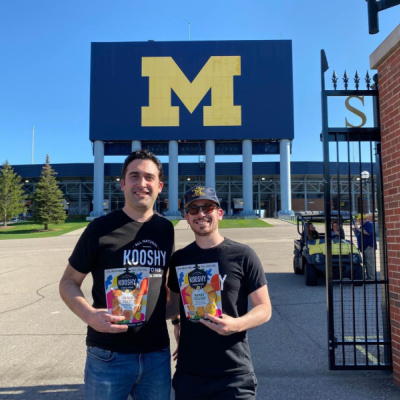 Photo of two people standing at the gate of Michigan Stadium.