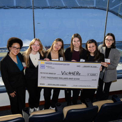 Six people smiling and holding a large check for $5,000 awarded to VicHERr.