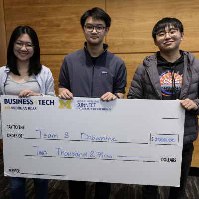 Three people holding a large check for two thousand dollars from the Ross Business+Tech Association.
