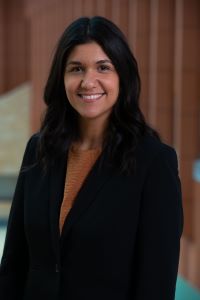 Photo of Alexandra Solis-Mullen, WMBA with long dark hair wearing a black suit and smiling