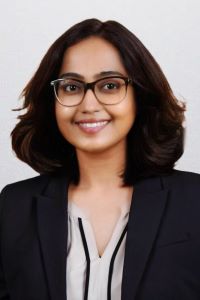 Photo of Irsha Pardashi PhD PTMBA student with dark hair wearing glasses and smiling 