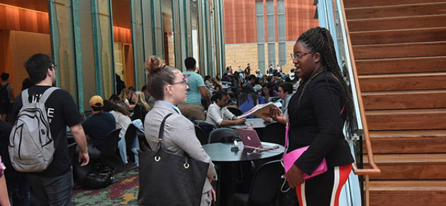 Students in the winter garden talking near the stairs