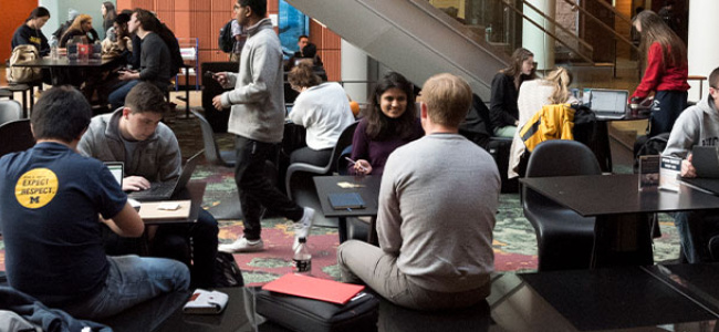 Students working and conversing in the winter garden