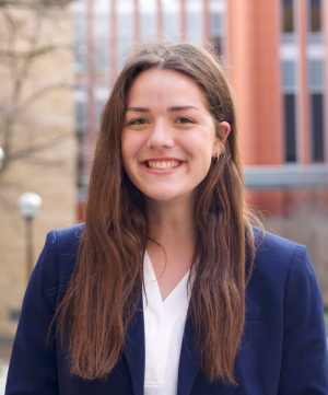 Woman with brown hair in blue blazer in front of Ross building