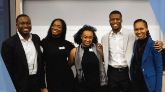 Five students stand smiling at the African Business Conference